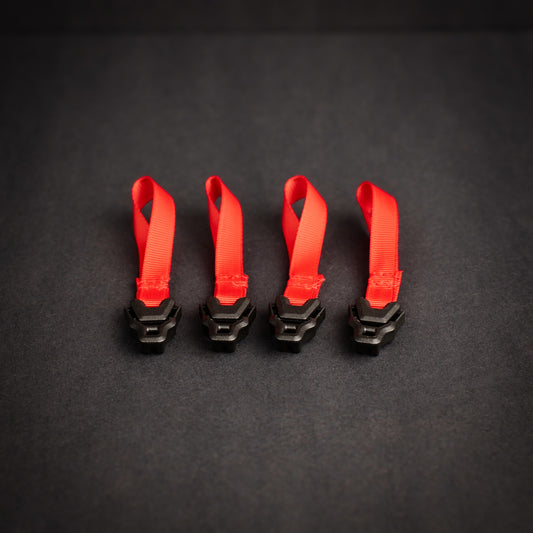 Four Z Buckle tensioners fitted to high-visibility red grosgrain loops for tarp, tent and shelter guyline adjustment