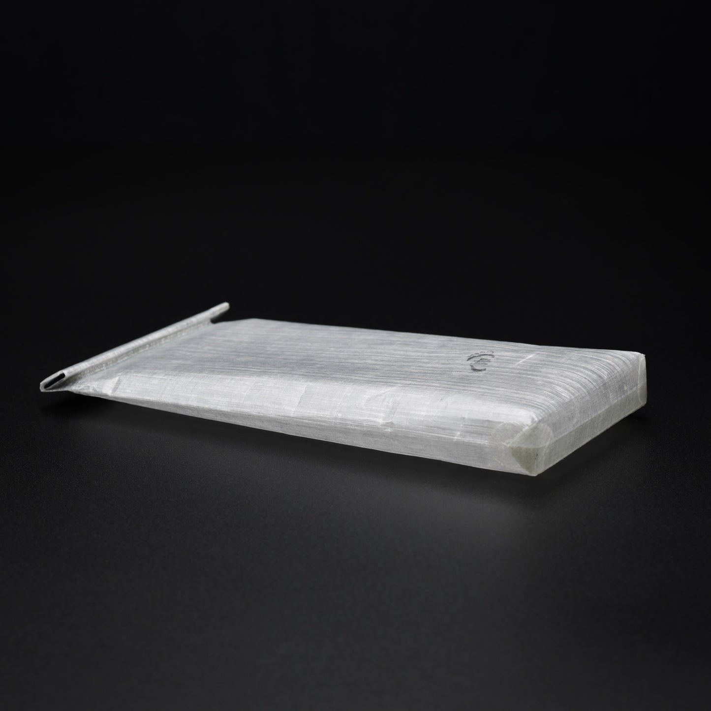 Rear angled view of a transparent 1.43 oz Dyneema® Composite Fabric power bank dry bag showing bonded construction and molded roll-top closure.