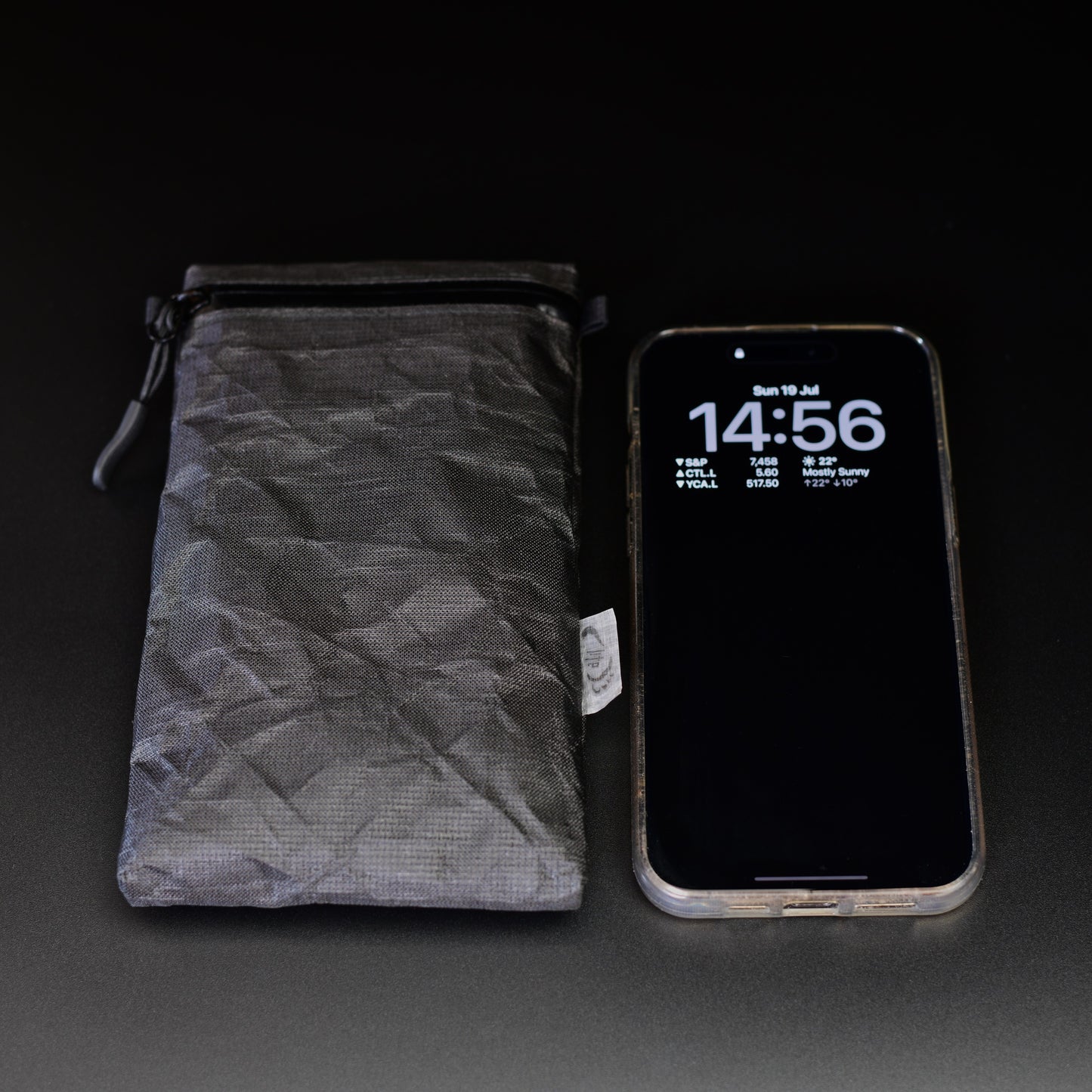 Ultra 200X backpack strap phone pouch beside an iPhone for size comparison, sized to fit all iPhone and Samsung Galaxy Max models.