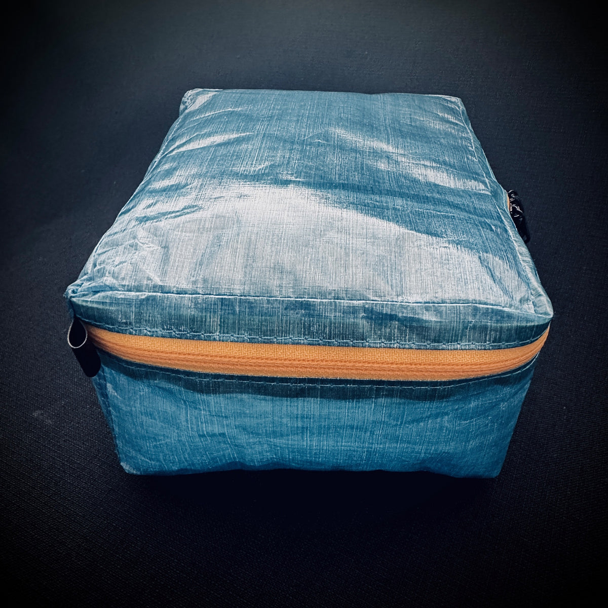 Side view of ultralight blue Dyneema® Mini Packing Cell with yellow AquaGuard zip and structured 8 cm depth.