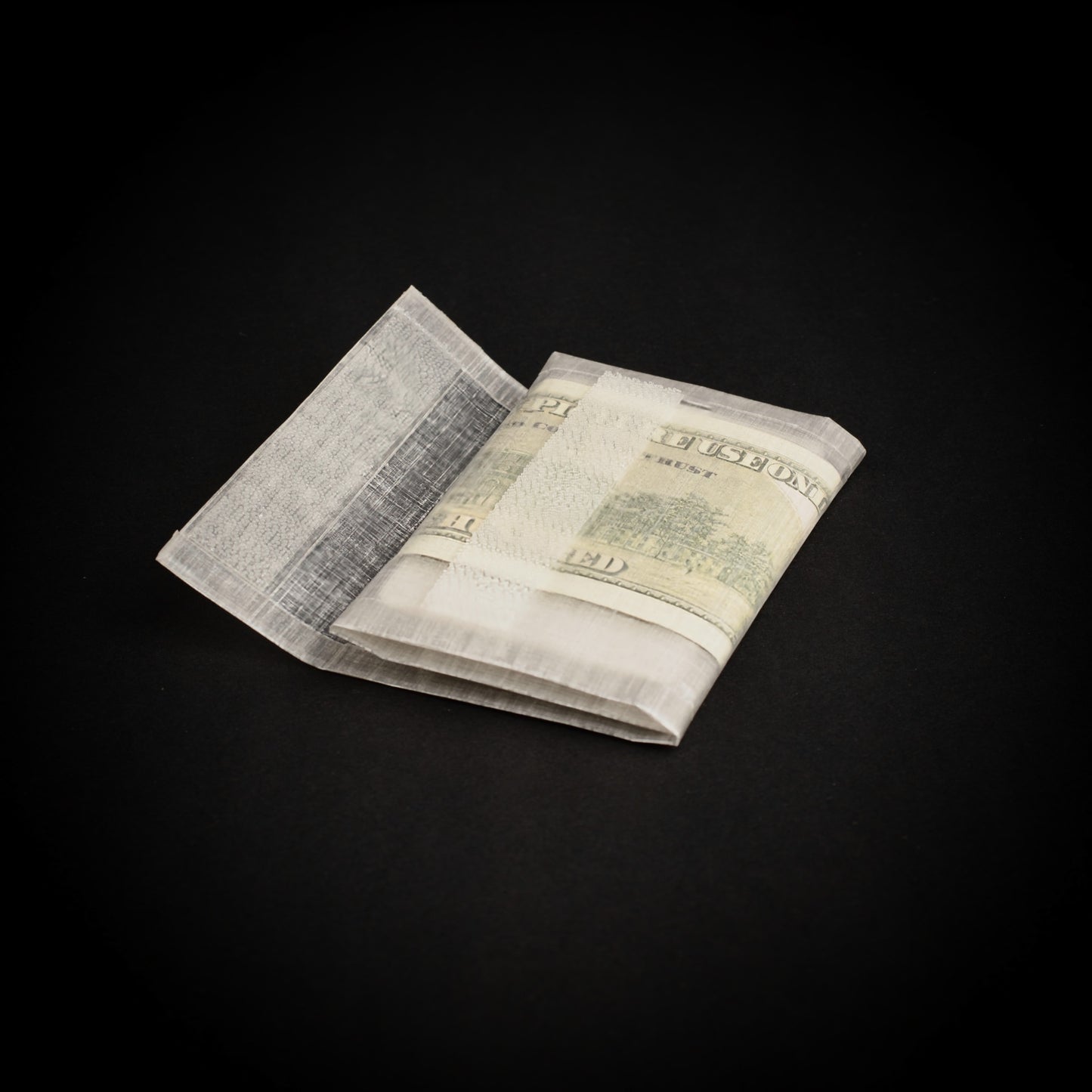 Ultralight adventure wallet partially opened to display cash storage, bonded seams and Dyneema Composite Fabric construction.