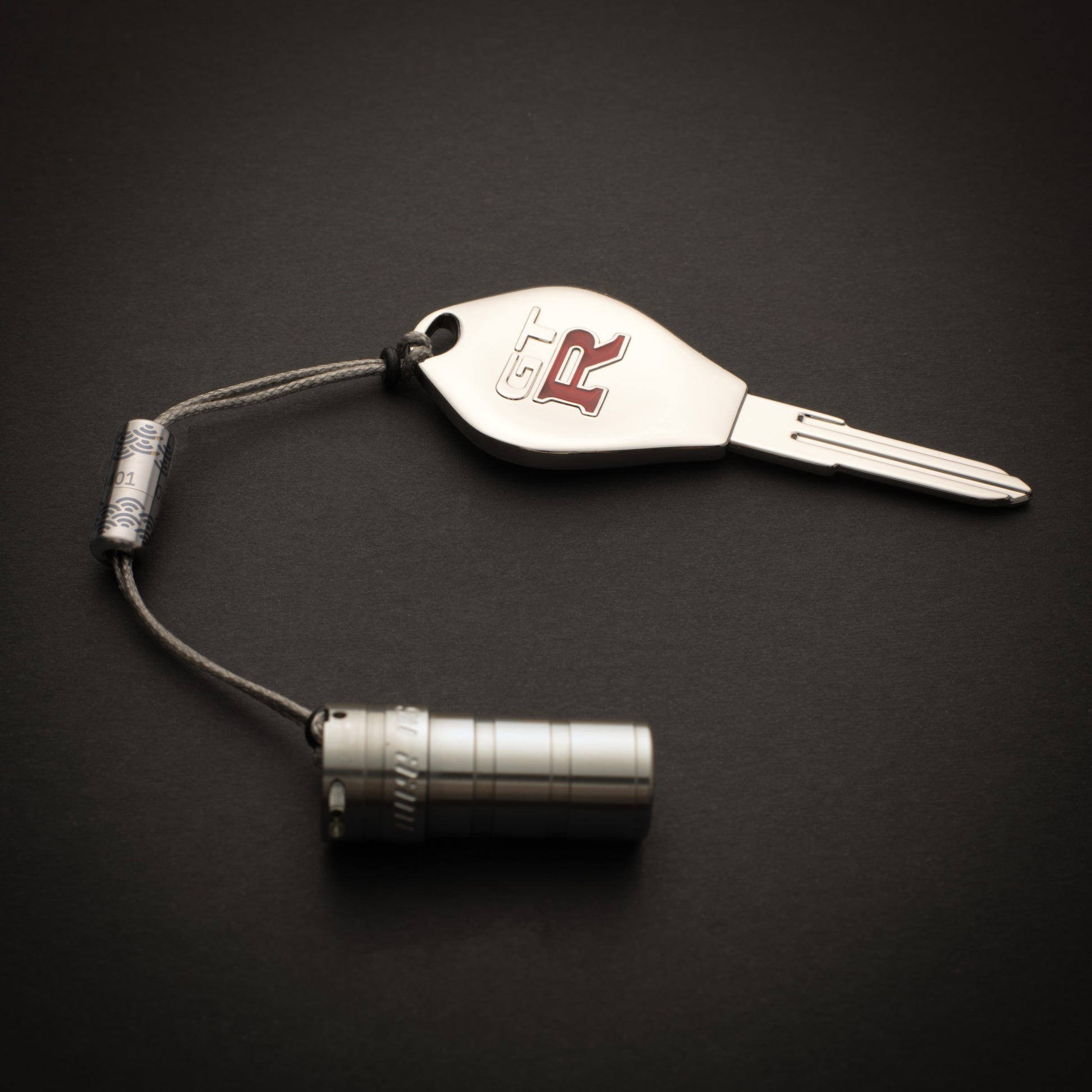 Titanium Bow-Ti connecting a key and compact flashlight with adjustable Dyneema loops