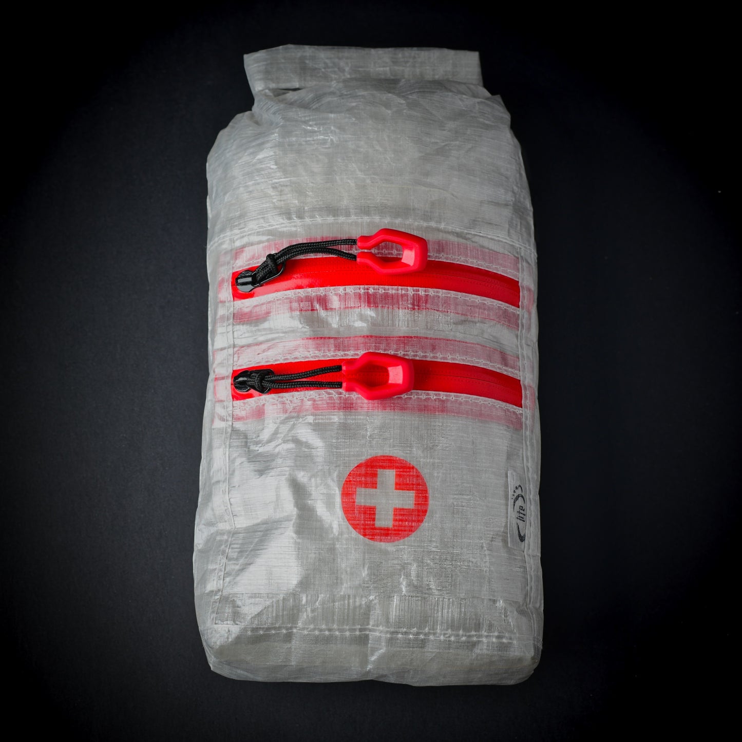 White Dyneema Composite Fabric first aid dry bag with two YKK AquaGuard zip pockets, roll-top closure and first aid cross