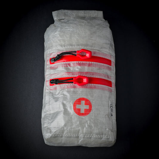 White Dyneema Composite Fabric first aid dry bag with two YKK AquaGuard zip pockets, roll-top closure and first aid cross