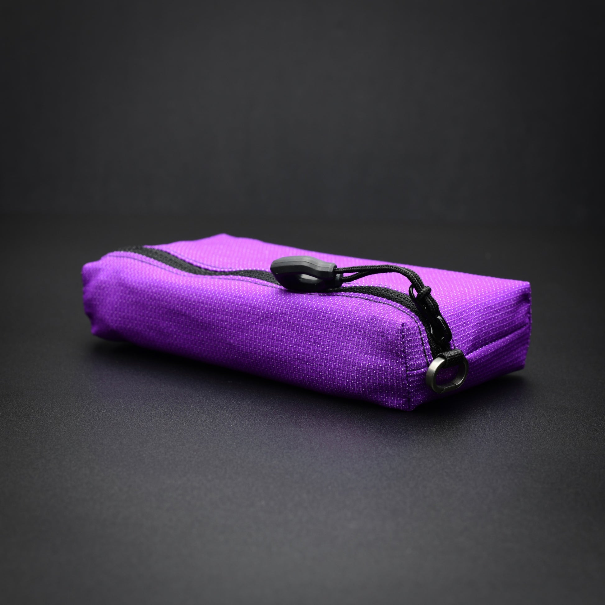 Low angled view of a purple UltraStretch™ expandable accessory case highlighting the stretch fabric and slim profile.