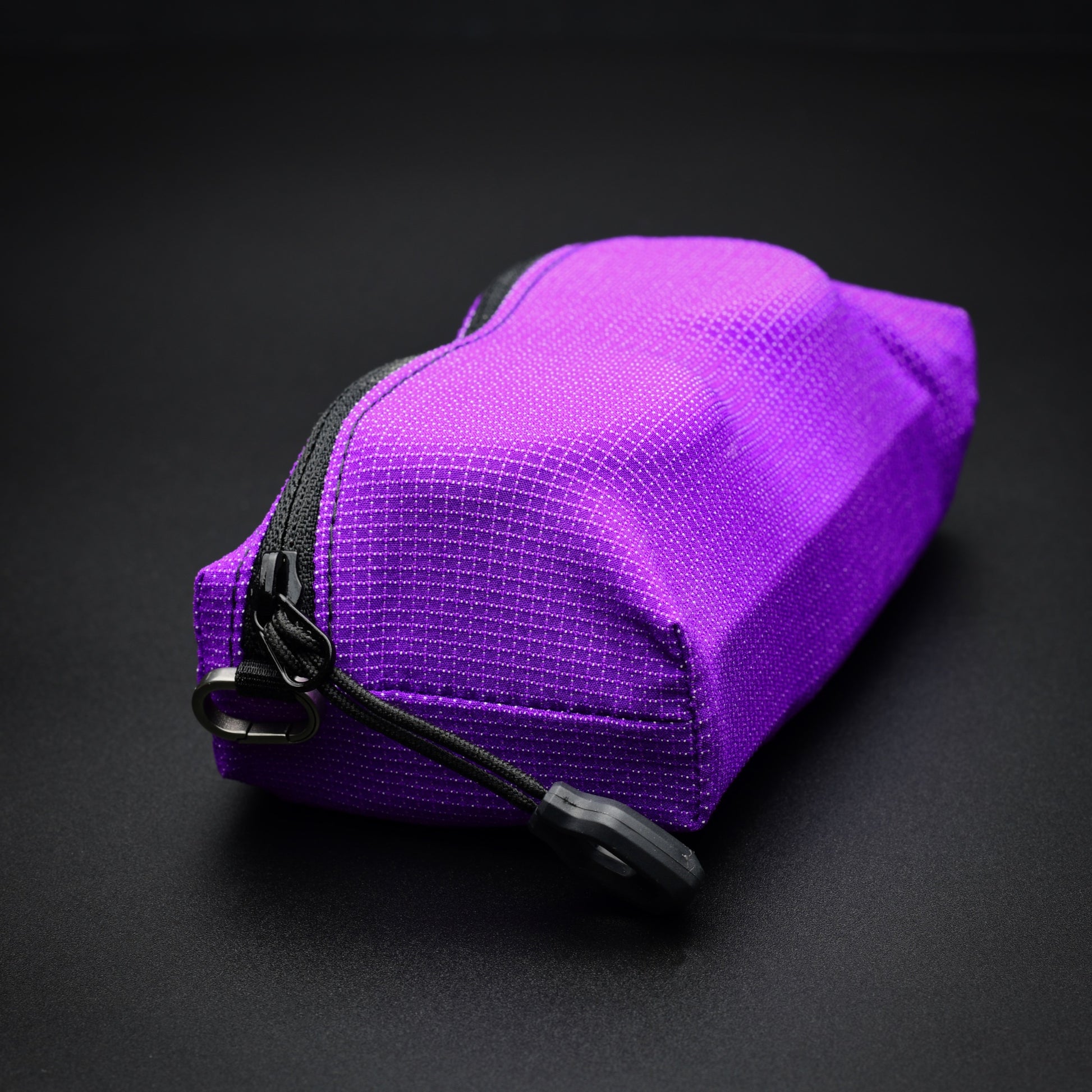 Rear three-quarter view of a purple UltraStretch™ expandable accessory case with abrasion-resistant stretch fabric and YKK® zip.