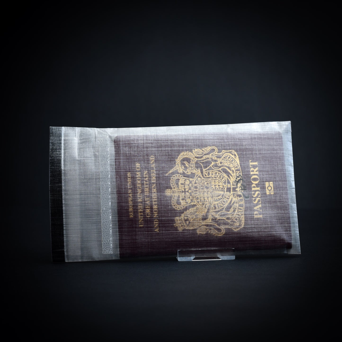 Handmade Dyneema Composite Fabric roll-top passport cover showing bonded construction and secure fold-over closure with UK passport.