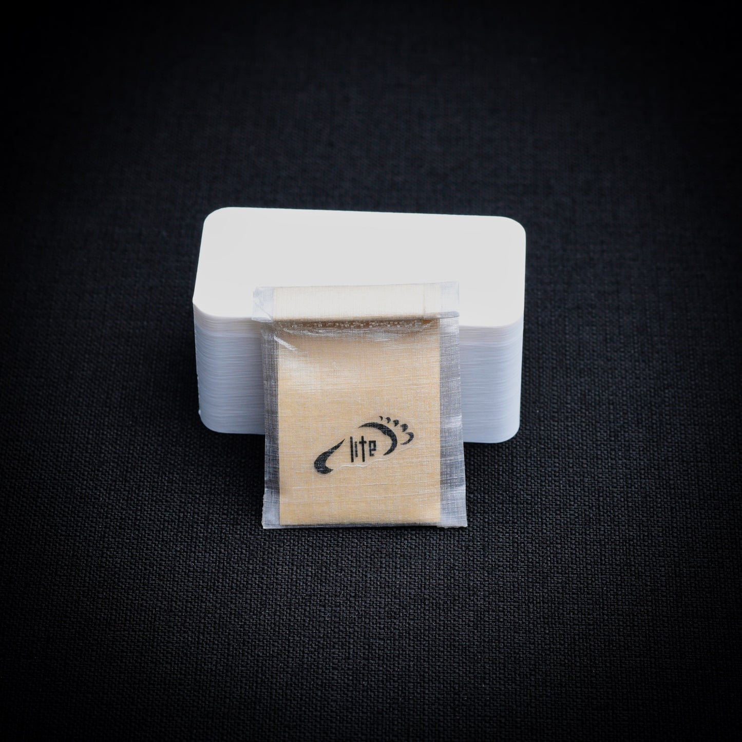DCF minor repair patch kit in a translucent roll-top mini dry bag, shown with protective kraft liner.