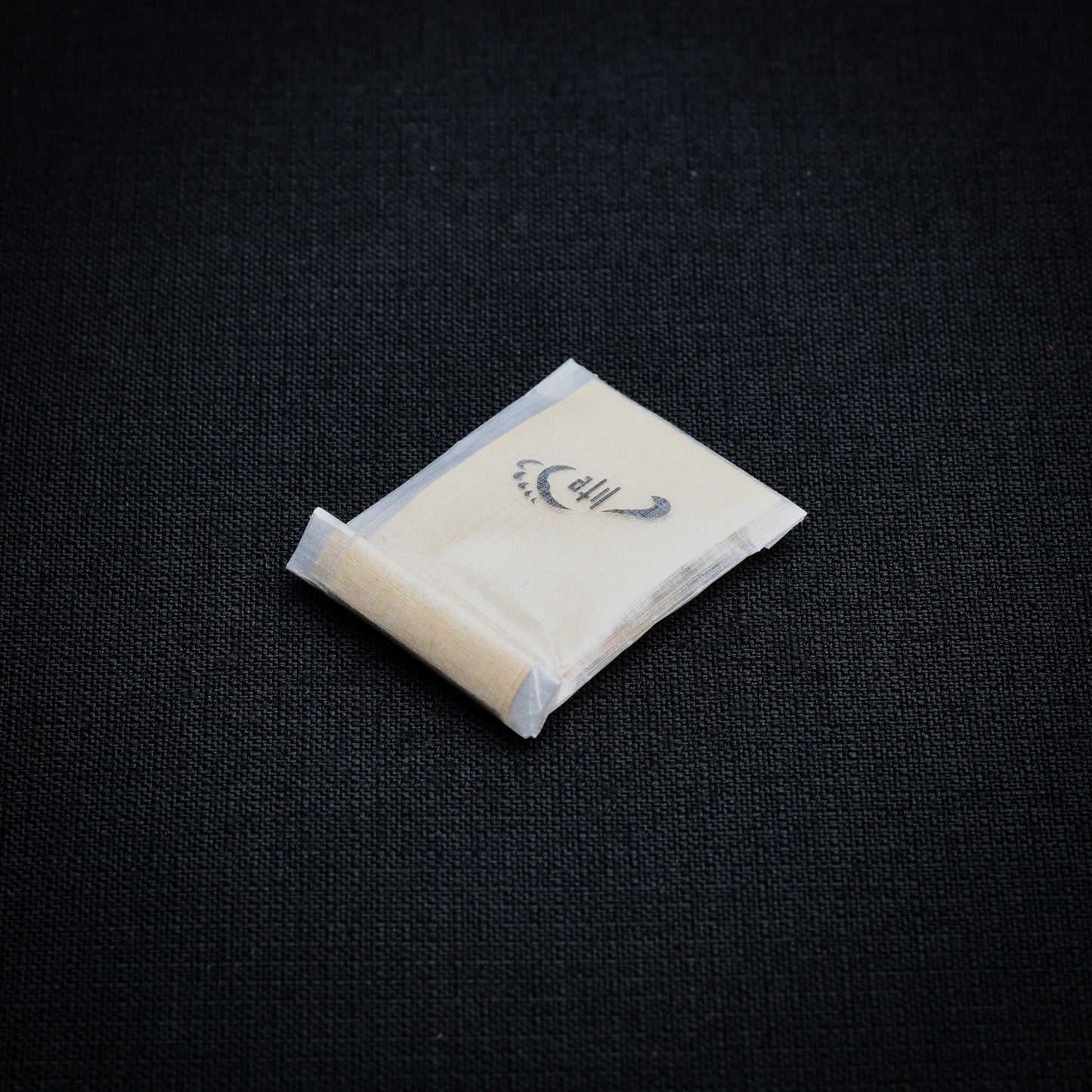 Lightweight DCF roll-top mini dry bag containing self-adhesive Dyneema Composite Fabric repair patches.