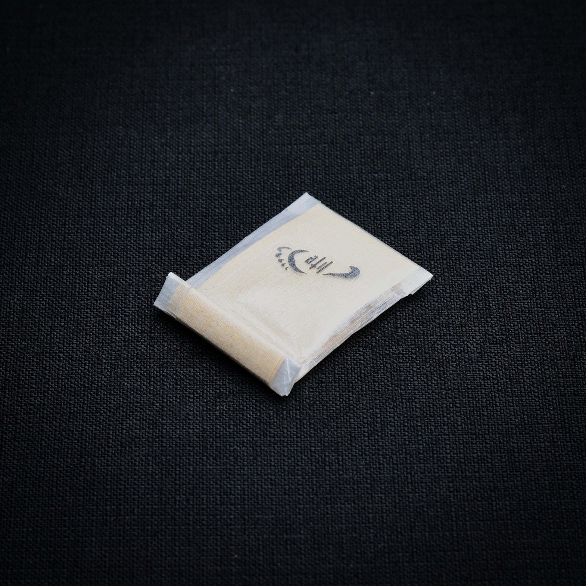 Lightweight DCF roll-top mini dry bag containing self-adhesive Dyneema Composite Fabric repair patches.