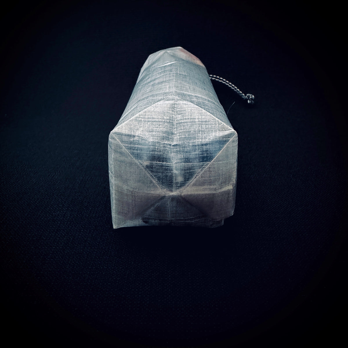 Close-up of the folded reinforced base construction on an ultralight translucent DCF tent stake bag.