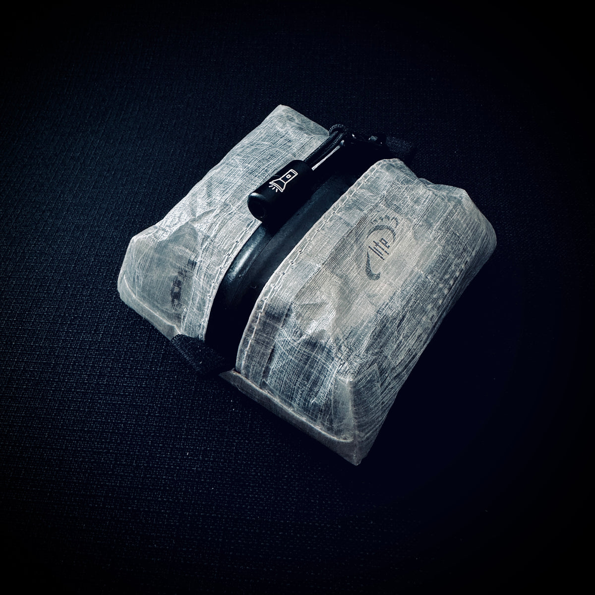 White DCF Nitecore NU25 UL headlamp pouch with YKK AquaGuard zip, engraved flashlight pull and Tread Lite logo.