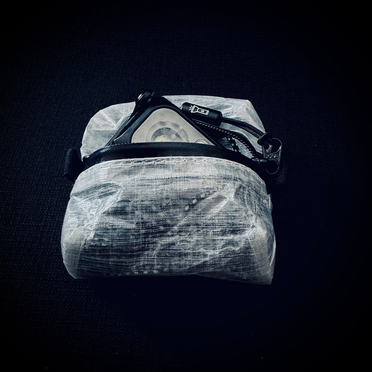Open DCF zip pouch showing a Nitecore NU25 UL headlamp and strap fitted inside.