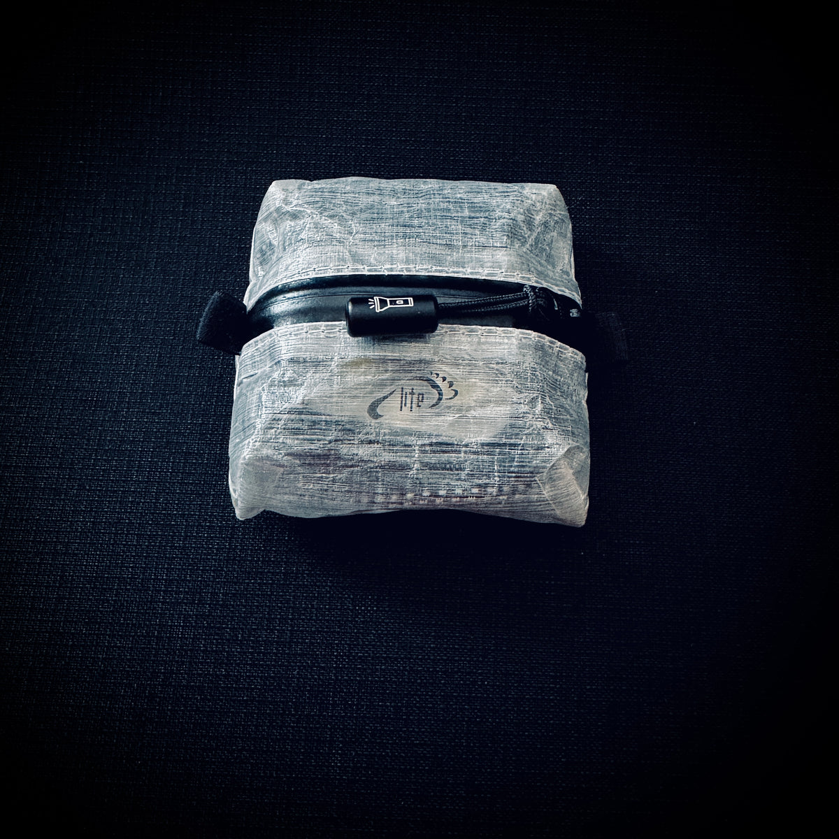 Ultralight DCF pouch for Nitecore NU25 UL, showing tapered Zoid construction, AquaGuard zip and engraved flashlight pull.