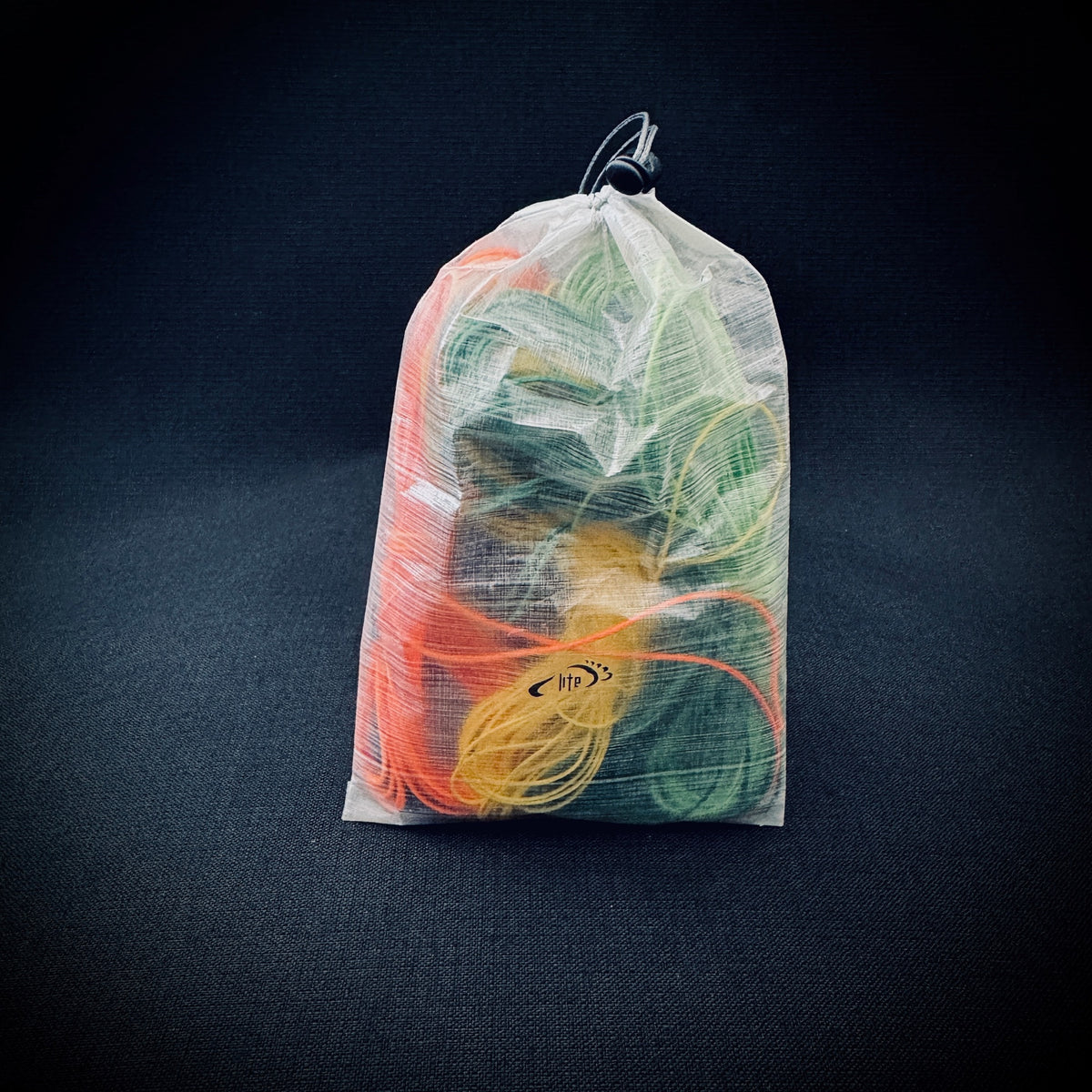 White bonded DCF ditty bag filled with coloured guylines and small camping accessories