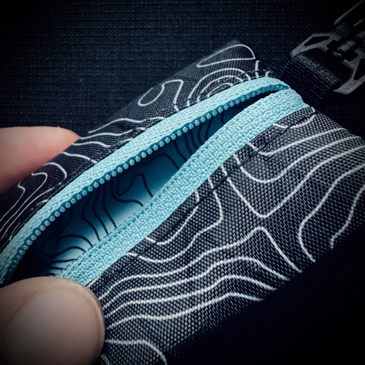 Open topo X-Pac micro utility pouch with blue YKK zip showing the blue topo-print polyester lining.