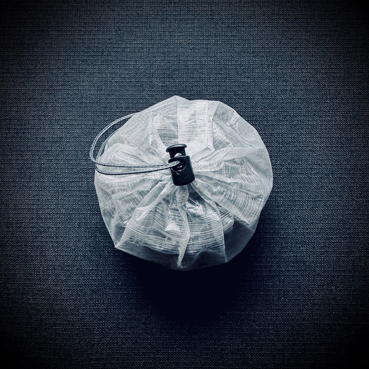 Dyneema Trangia burner stuff sack closed with its drawcord and micro cord lock.