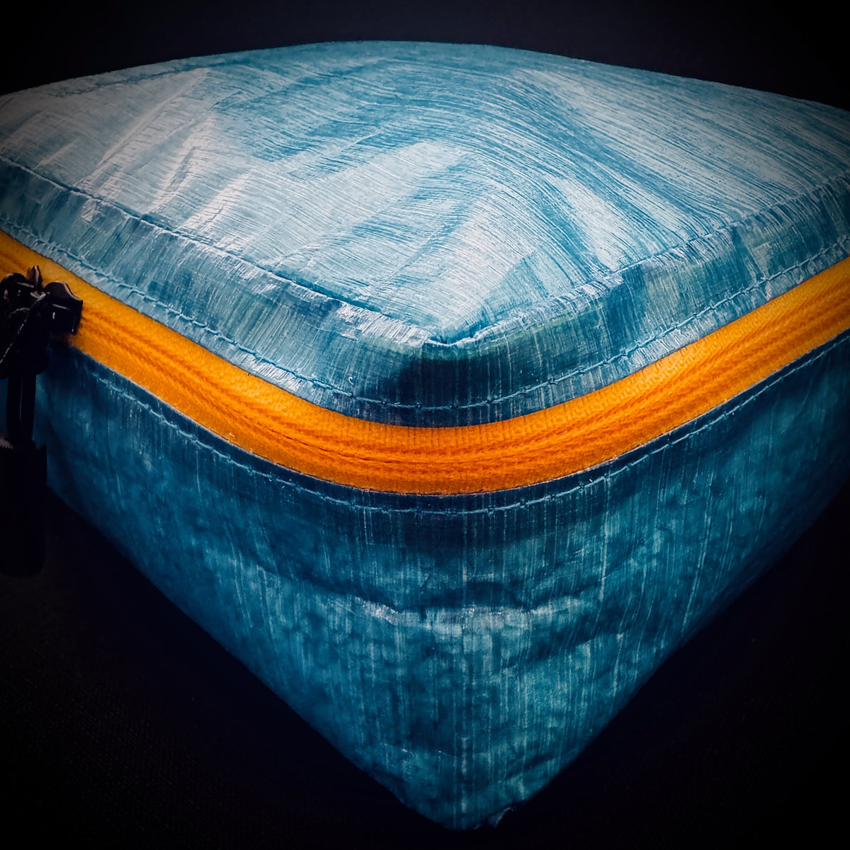 Close-up of blue Dyneema® Composite Fabric packing cell showing the translucent DCF texture, seams and yellow AquaGuard zip.