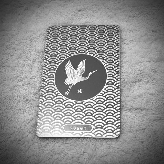 Portrait view of Kōsen Object 002 Harmony titanium art card with crane, Seigaiha wave pattern and 和 kanji.