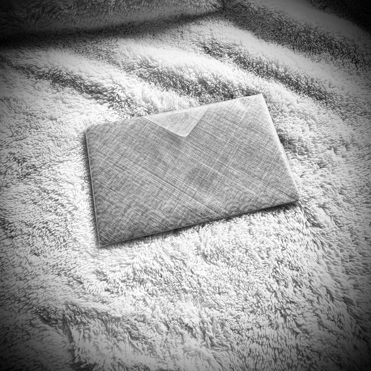 Folded Dyneema Composite Fabric protective wrap supplied with the Kōsen titanium art card.
