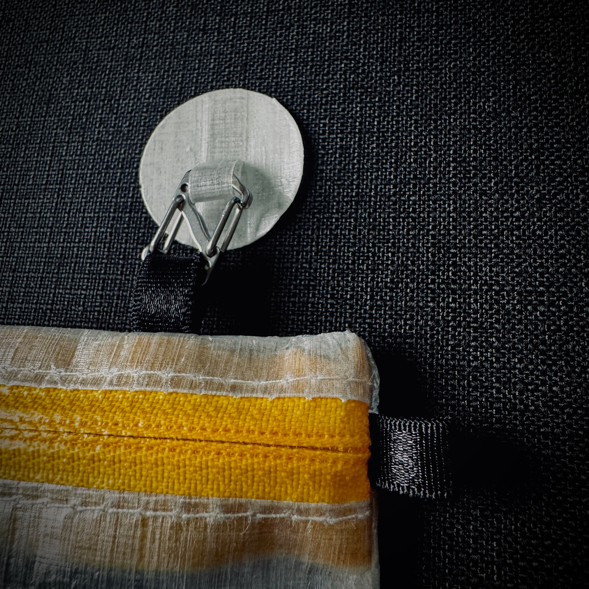 Close-up of a Microdot clip attached to the pouch’s elasticated tab.