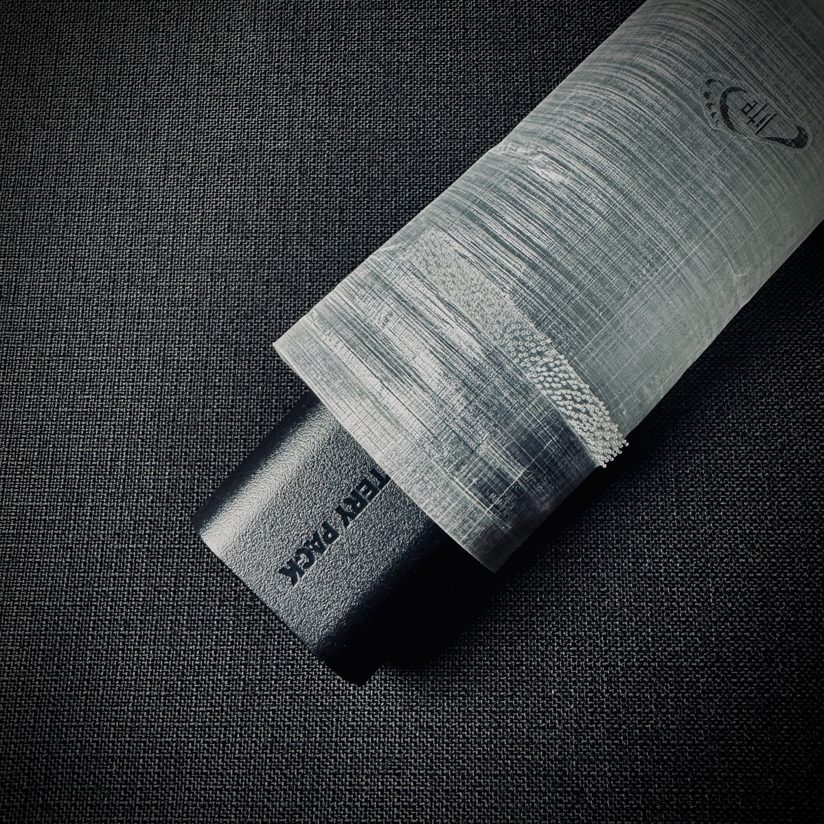 Camera battery partially inserted into the DCF dry bag, showing the opening and closure.