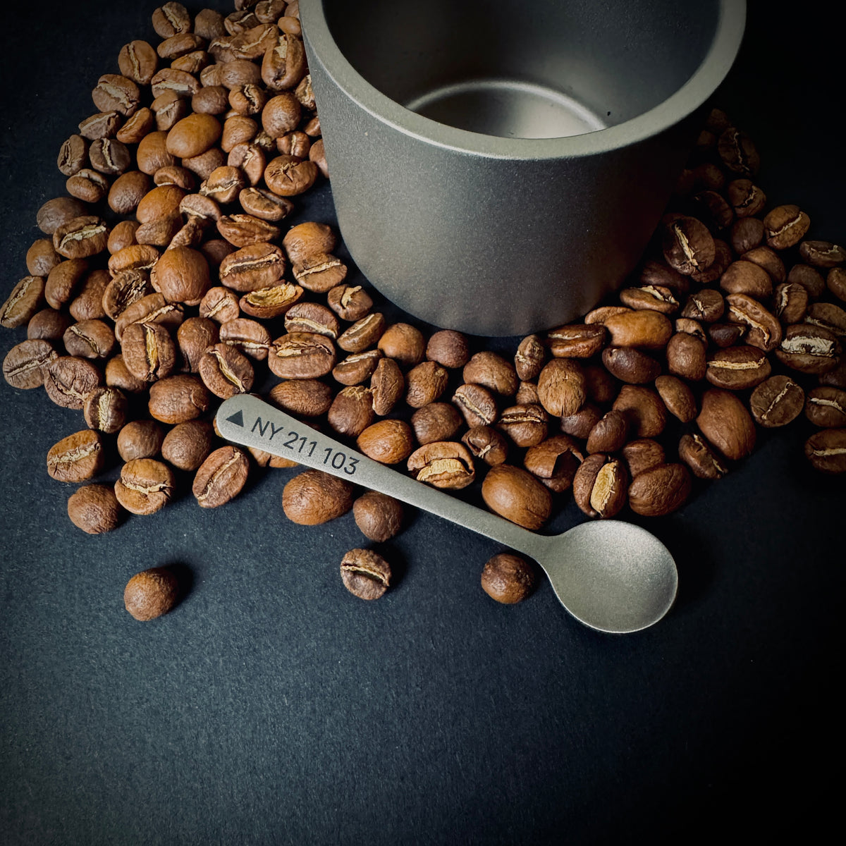 1. Custom titanium coffee spoon with Great Gable grid reference NY 211 103, shown horizontally among coffee beans.