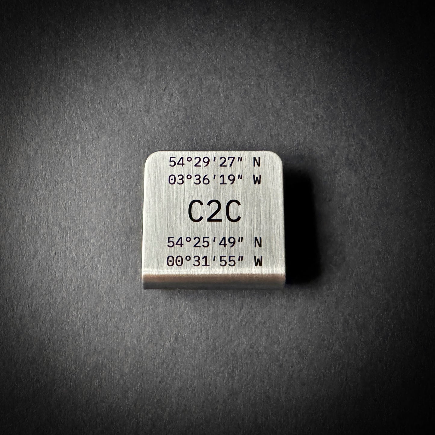 Coast to Coast stainless steel hat brim clip with laser engraved route coordinates and brushed finish