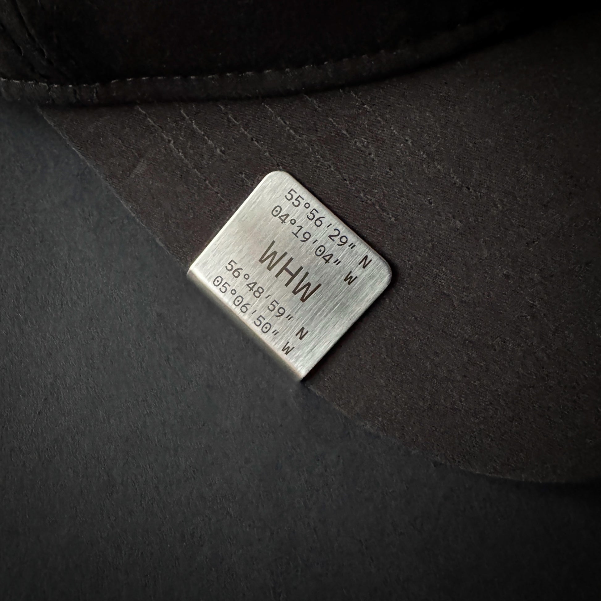 Angled view of West Highland Way coordinate hat brim clip in brushed stainless steel