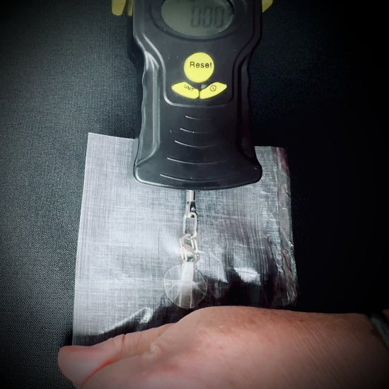 A Microdot adhesive hanging point attached to DCF is pull-tested using a digital scale.